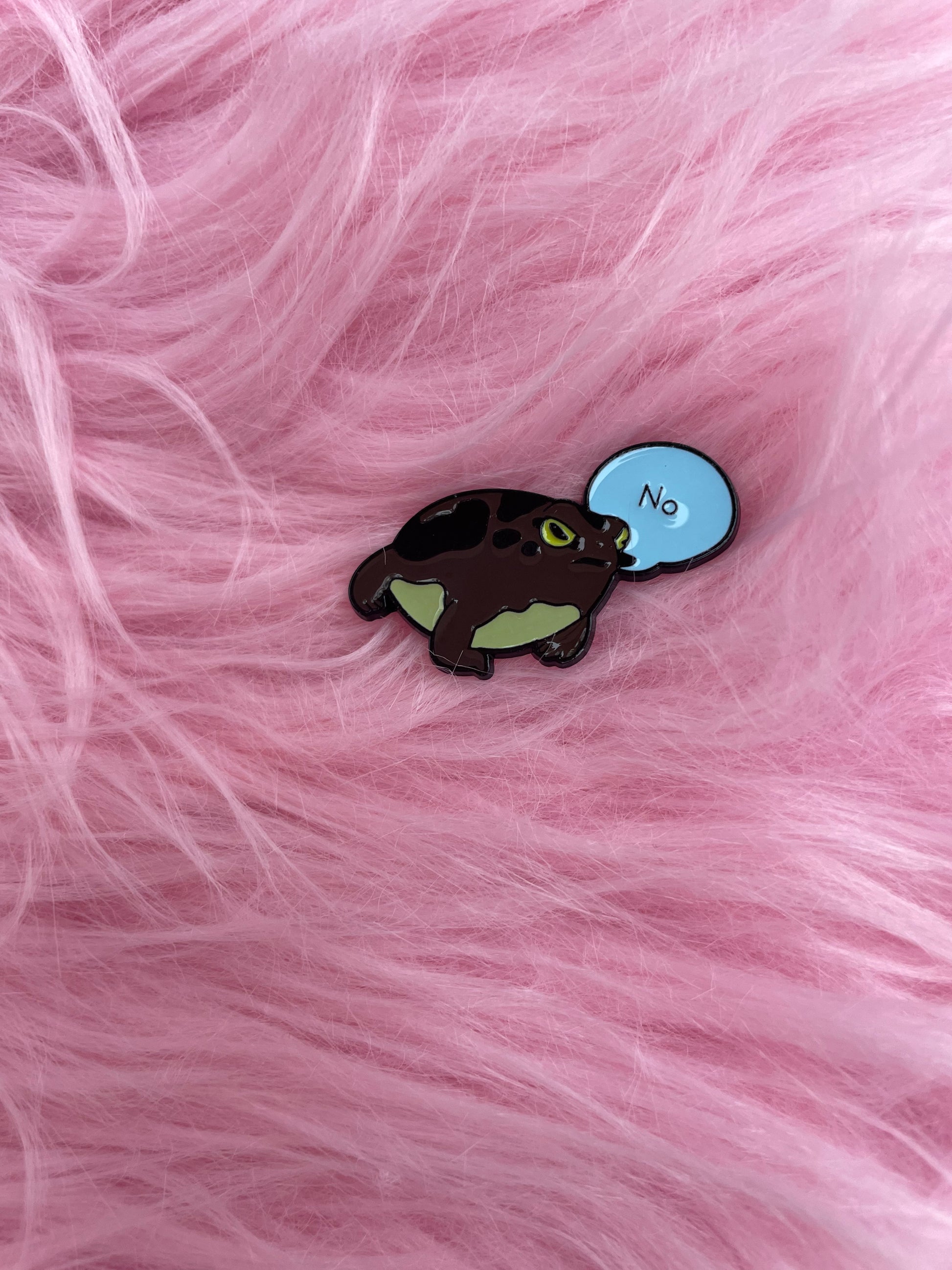Frog saying no, enamel pin on pink fur